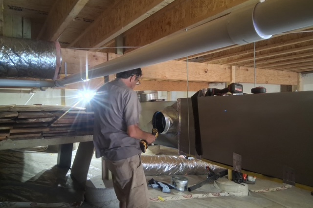 HVAC technician working on a capacitor part for condensing unit. Male worker or repairman in uniform repairing and adjusting conditioning system, diagnosting and looking for technical issues.